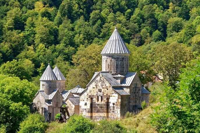 Ancient Tatev Monastery in Armenia, surrounded by lush green forest