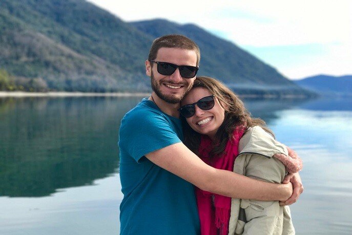 Romantic couple hugging near a scenic mountain lake – best travel tips for couples for romance, bonding, and adventure.